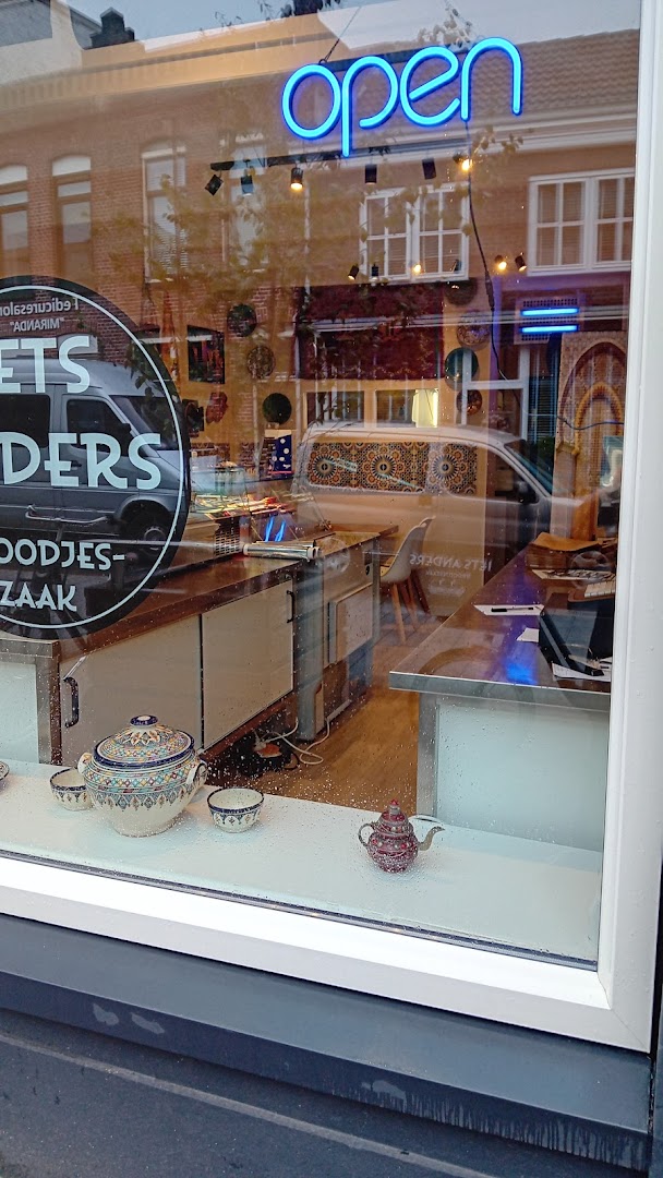Het neon Open-bord in de etalage van Iets Anders Broodjeszaak in de avond